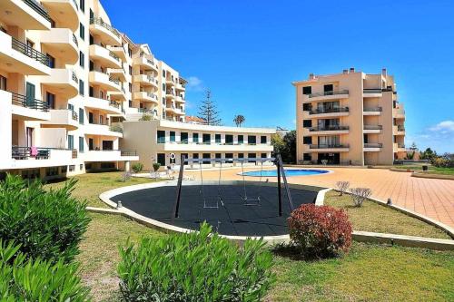 a basketball court in front of a apartment building at Pia's Place - Apt with sea view in Caniço