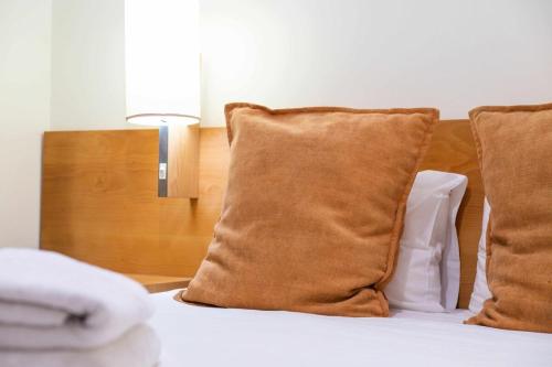 a bed with two pillows and a lamp on it at Garajau Terrace - Amazing Views of Garajau Town in Garajau