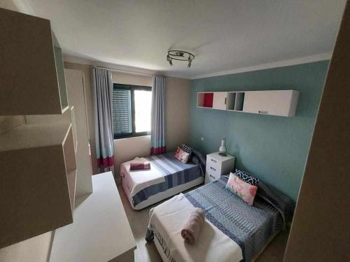 フンシャルにあるGuestReady - Nora Premiumのベッド2台とソファが備わる小さな客室です。