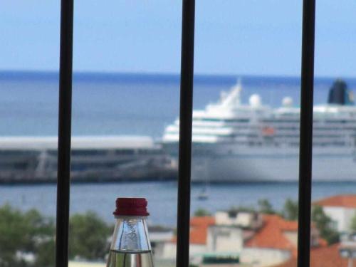 a glass bottle with a cruise ship in the background at GuestReady - Nora Premium in Funchal