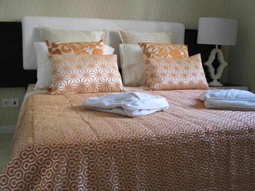 a bed with two towels sitting on top of it at GuestReady - Nora Premium in Santa Luzia