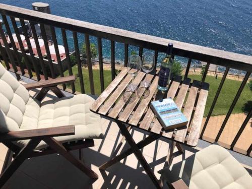 a wooden table and chairs on a balcony at Cliff View III - Sea View + Pool + Wifi in Ilhéu do Gorgulho