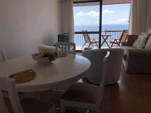 a living room with a table and chairs with a view at Cliff View III - Sea View + Pool + Wifi in Ilhéu do Gorgulho