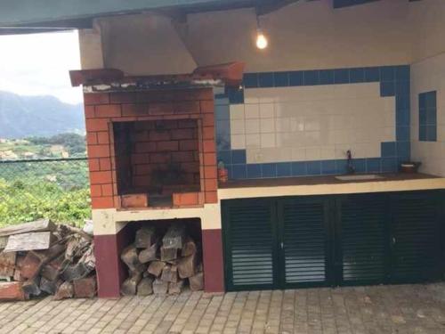 un edificio con due porte del garage e un mucchio di legno di GuestReady - Casa Avó Alice a Porto da Cruz