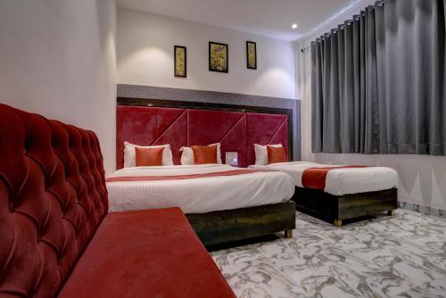 a hotel room with two beds and a red headboard at Hotel Golden Palace Residency in Mumbai