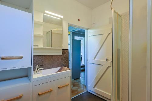 une salle de bain avec un lavabo et un miroir dans l'établissement Atypique, cabanon bord de mer, à Hyères