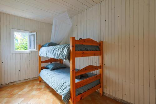 une chambre avec deux lits superposés et une fenêtre dans l'établissement Atypique, cabanon bord de mer, à Hyères
