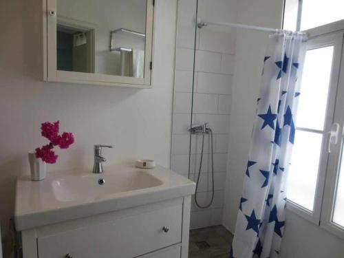 a bathroom with a sink and a shower curtain with blue stars at Barreirinha II Perto da Cidade Velha Com Vista do Oceano de Nice in Funchal