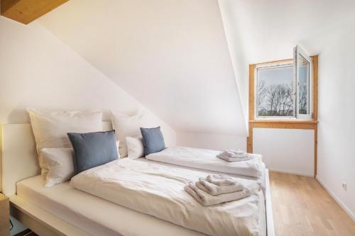 Cama blanca en habitación con ventana en Lautertal Loft en Blaustein