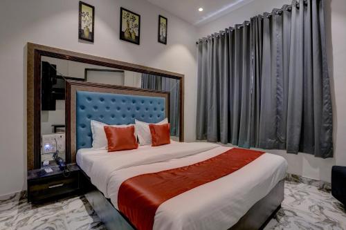 a bedroom with a large bed with orange pillows at Hotel Golden Palace Residency in Mumbai