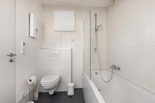 a white bathroom with a toilet and a bath tub at Lautertal Loft in Blaustein