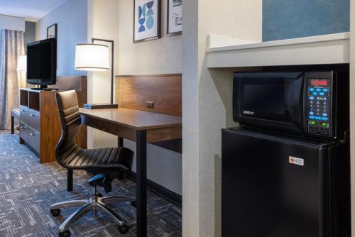 a hotel room with a desk with a tv and a computer at Wingate by Wyndham Vineland in Vineland