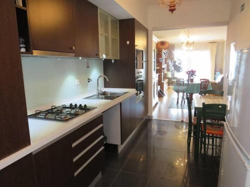a kitchen with a sink and a stove top oven at GuestReady - Tamariz Cosy Stay in Caniço