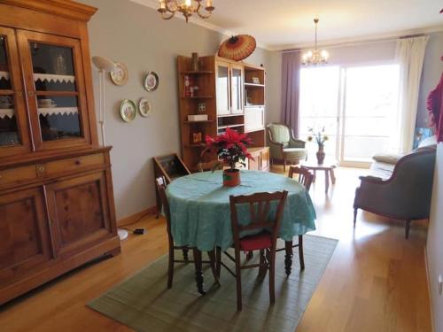 a living room with a table and chairs in a room at GuestReady - Tamariz Cosy Stay in Caniço