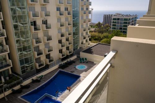 een uitzicht vanaf het balkon van een gebouw met een zwembad bij GuestReady - Scenic Retreat with Seaview in Funchal