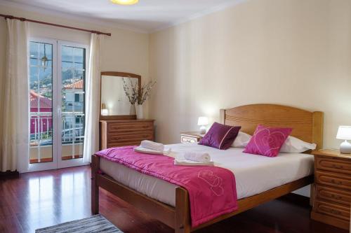 a bedroom with a large bed with purple pillows at GuestReady - Tranquil Spot in São Vicente in São Vicente