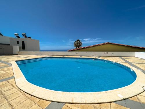 a large blue swimming pool on a tiled patio at GuestReady - A splendid sea-view stay in Caniço
