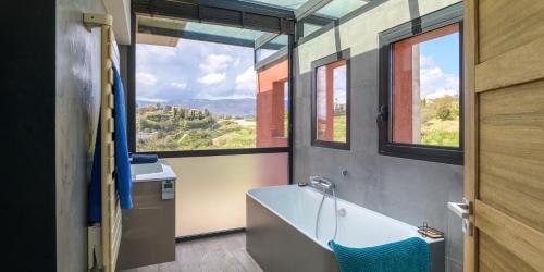 a bathroom with a tub and a large window at Villa Piscine vue mer plein sud in Nice