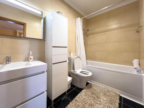 een badkamer met een wastafel, een toilet en een bad bij GuestReady - One happy stay in Machico in Santa Cruz