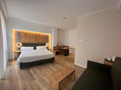 a bedroom with a white bed and a wooden floor at Hotel America in Trento