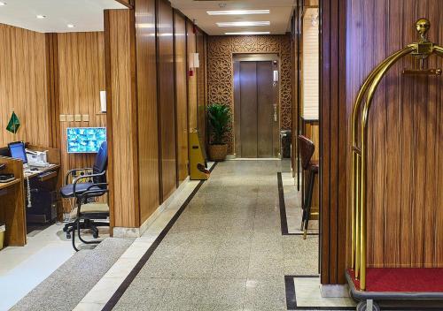 an office hallway with wooden walls and a door and chairs at غرف فندقية هارودز in Jeddah