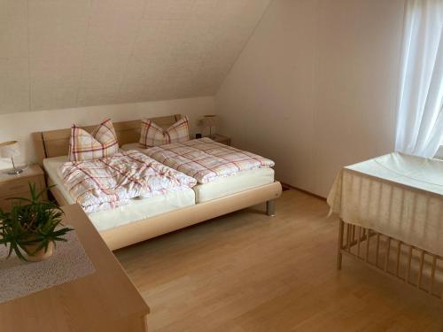 Schlafzimmer mit einem Bett mit Kissen und einem Tisch in der Unterkunft Ferienhaus Rennsteigblick in Eisfeld