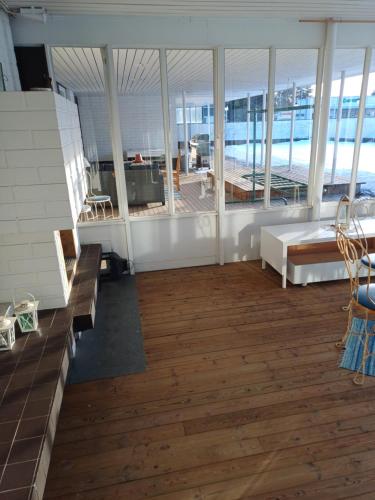een grote kamer met houten vloeren en grote ramen bij Majoitus Yli-Torkko in Seinäjoki