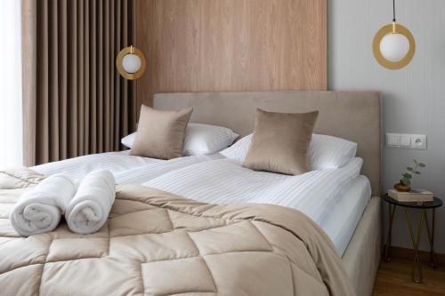 a bedroom with a white bed with towels on it at Apartament VERON w Kościelisku - balkon z widokiem na góry, parking w cenie in Kościelisko