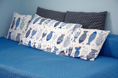 a blue and white couch with four pillows on it at Cà da Nalda in Lavagna