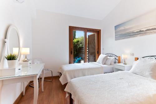 - une chambre blanche avec 2 lits et un bureau dans l'établissement 2 bedroom Villa Kornos with private pool and golf views, Aphrodite Hills Resort, à Kouklia
