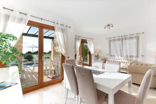 a white dining room with a white table and chairs at 2 bedroom Villa Kornos with private pool and golf views, Aphrodite Hills Resort in Kouklia