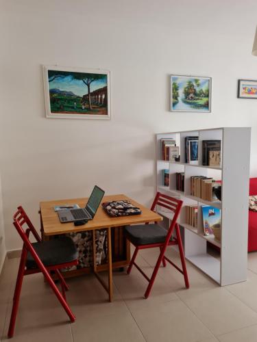 Zimmer mit einem Tisch mit 2 Stühlen und einem Laptop in der Unterkunft Cozy studio flat in Rome in Rom