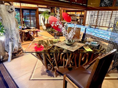 a room with a glass table with flowers and umbrellas at Kominka Mitsuhama Ryokan in Matsuyama