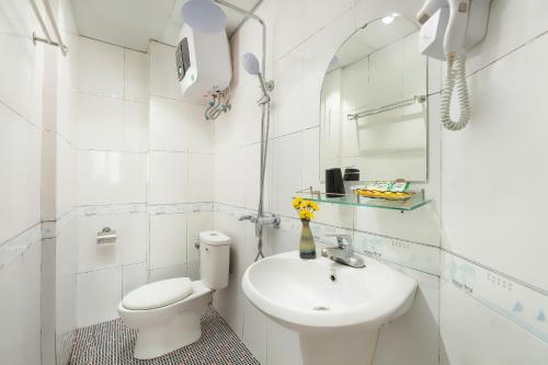 a white bathroom with a toilet and a sink at Golden Time Hostel 3 in Hanoi