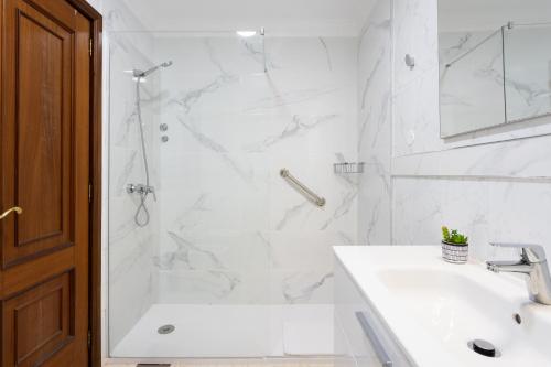 biała łazienka z prysznicem i umywalką w obiekcie New Bright and Central Home with 2 bedrooms w Puerto de la Cruz