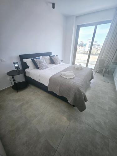 um quarto com uma cama grande e uma janela grande em One bedroom apartment, Universal Residences em Pafos