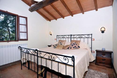 um quarto com uma cama preta e uma janela em Villa Giara - Piscina vista Lago Trasimeno Umbria em Paciano