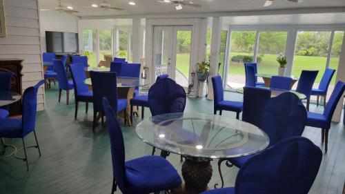 a room with blue chairs and a glass table at Fairfax Bed and Breakfast in Franklin