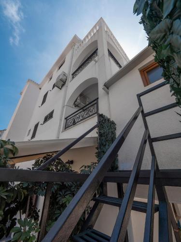 a white building with a staircase in front of it at Apartments Mary in Budva