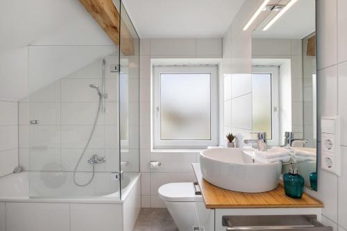 a white bathroom with a sink and a shower at Blaustein Loft in Blaustein