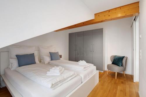 een groot wit bed in een kamer met een stoel bij Blaustein Loft in Blaustein