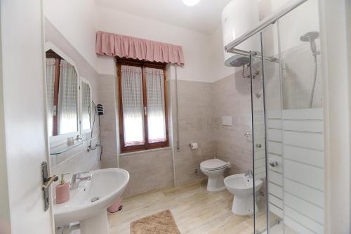 a white bathroom with a sink and a toilet at B&B Antica Dimora in Olbia