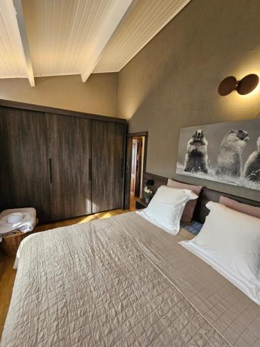 a bedroom with a large bed with white pillows at LAC ACHETTE AU LAC in Butgenbach