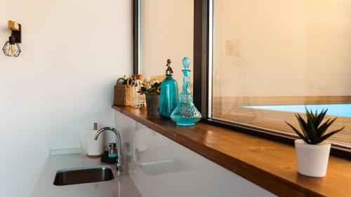 un mostrador de baño con jarrones sobre una ventana en Cal Comorera, en Massoteres