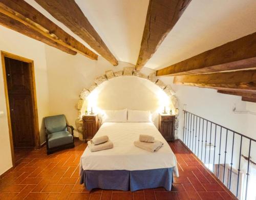 una camera con un letto bianco e una sedia di Cal Comorera a Masoteras