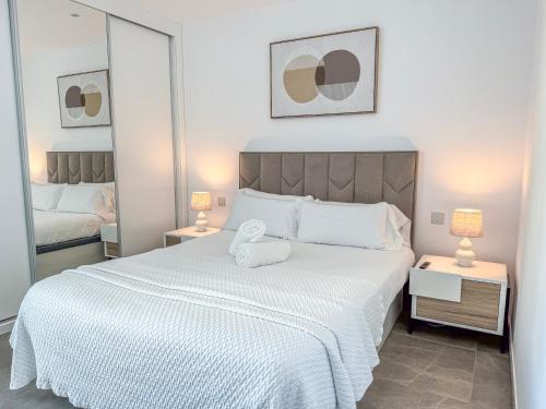 a bedroom with a large white bed with towels on it at E1 Suites & Spa aparthotel style - Gym & Spa in Gibraltar