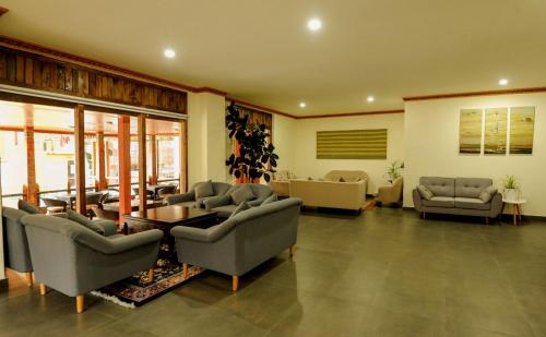 un soggiorno con divani, sedie e tavolo di Eutsholing Boutique Hotel a Thimphu