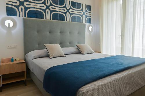 a bedroom with a large bed with a blue blanket at Charming Rooms Amalfi Coast in Maiori