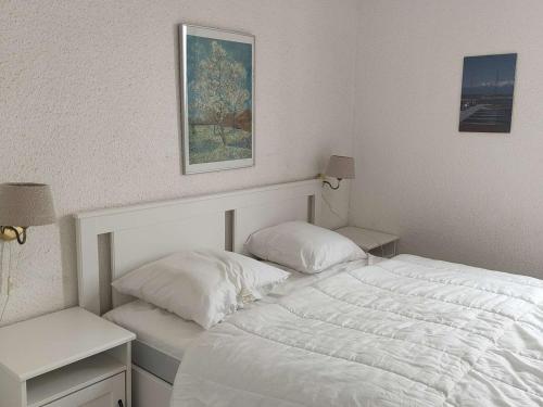une chambre blanche avec un lit et deux tables de nuit dans l'établissement Appartement T2 avec Terrasse et Piscine, Parking Privé, Espace Aquatique - Le Barcarès - FR-1-195-22, au Barcarès