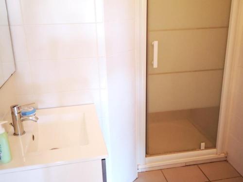 une salle de bain avec un lavabo et une douche dans l'établissement Appartement T2 avec Terrasse et Piscine, Parking Privé, Espace Aquatique - Le Barcarès - FR-1-195-22, au Barcarès